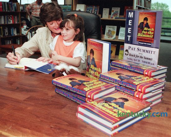 Six year-old Kathleen Dawson of Lexington sets on Pat Summit's lap as she autographs a copy of her new book Reach For the Summit,  for Dawson's mother.  Dawson brought Summit a KY Derby Beanie Baby for her son Tyler.  April 28, 1998