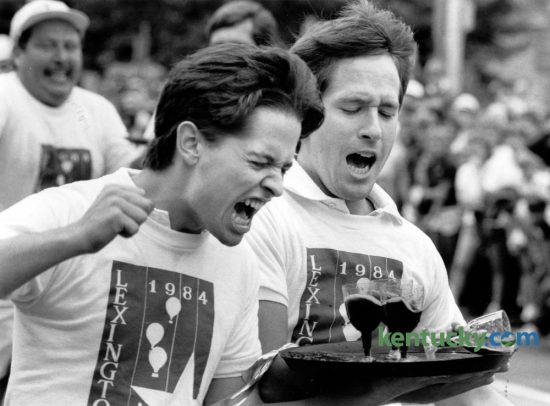 James Baker, left, and David Trice react after spilling a glass of wine in the waiter's race in downtown Lexington on July 4, 1984. The race was then part of Lexington's Fourth of July celebration. Baker and Trice, representing the Lafayette Club, were in first place and were about 20 feet from the finish line when their glass toppled over. Lexington's 2016 Fourth of July festival will be held Monday. Photo by Gary Landers  | Staff