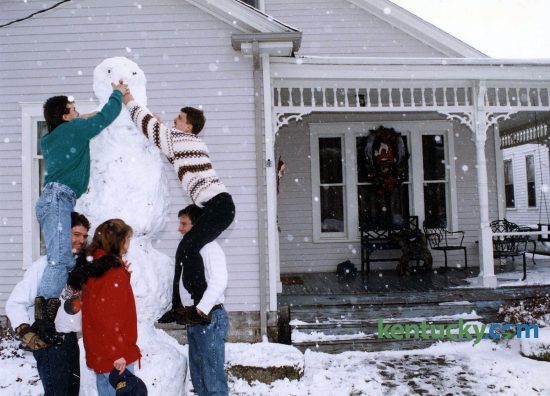Alex Heim, top left, got a lift from his brother Kevin and John Heim, top right, got a lift from Tony Smith while Alesia Smith supoervised the building of their snowman, Dec. 25, 1993. The five were putting the finishing touches on the 9-foot-tall snowman on Park Avenue in Lexington, which celebrated the white Christmas, but later paid for it as the snow turned to ice overnight makming travel difficult. Photo by Mark Cornelison | staff