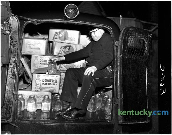 Lexington officer James Kenton shows there was not much room for those arrested after the liquor was loaded in a police vehicle, Jan. 11, 1951. The house at 536 Brown Court was raided in what police described as the biggest moonshine raid in local history. 188 gallons of the liquor were well hidden under the kitchen floor, which was accesiable through a trap door. All of the moonshine was stored in fruit jars, officers said. Four men were arrested during the raid. Herald-Leader archive photo