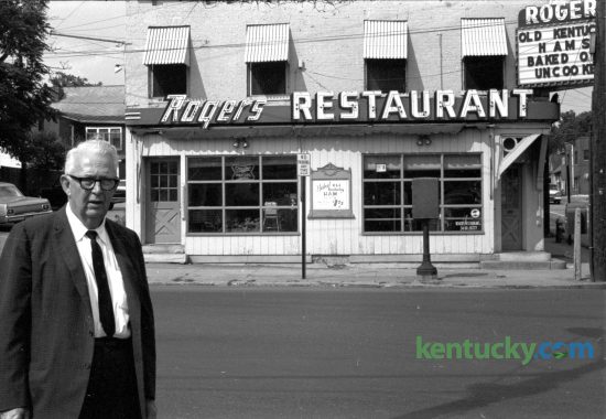 George Rogers in front of his restaurant at 601 West Main Street in June of 1965 after announcing plans to move the popular eatery to 808 South Broadway. Rogers bought the a former confectionery, located at the corner of Jefferson St. and West Main, in 1923. Rogers Restaurant featured home-style cooking and included hams he cured himself from hogs raised on his Woodford County farm. He sold the restaurant in 1974 to Charles Ellinger, who bought it as a Valentine's gift to his wife, Jan. Ellinger's son, Chuck Ellinger eventually took over the restaurant. Lexington's oldest restaurant closed it's doors on July 17, 2004. Published in the Lexington Herald June 19, 1965. Herald-Leader Archive Photo
