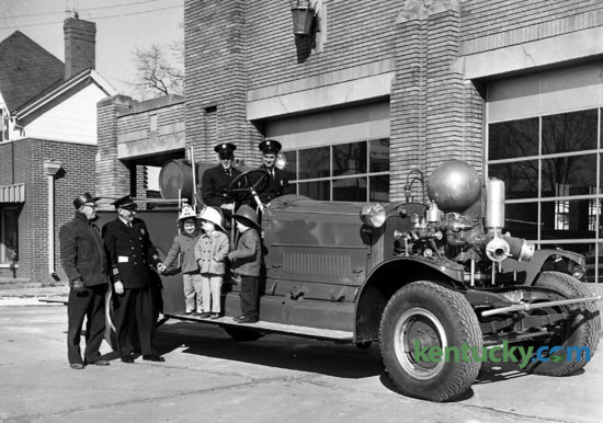 Old Engine No. 1 left Central Fire Station January 12, 1962 on its way to semi-retirement. The engine was given by the Fire Department to the Lexington Recreation Department to be used summers at the city playgrounds for children to climb on. Fireman Conrad Wells is in the driver's seat, and Fireman Raymond Stamper is beside him. Getting a free ride on the running board are Kime Tice Daniel, Debbie Watts and Stephen Wise. W.H. Brown, left, maintenance foreman of the recreation department, and Fire Chief HlL. Petit, watched the engine leave. The engine didn't run, but it was to be pulled from playground to playground during the summer and left at each  for four or five days. The engine was purchased in 1916 for $13,000 and made all major fire runs from then until 1949. Published in the Herald-Leader January 14, 1962. Herald-Leader Archive Photo