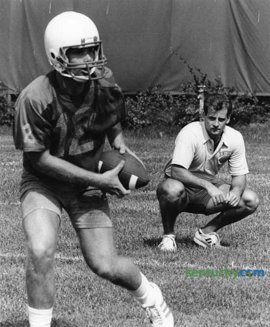A knee injury forced Doug Martin, right, to give up his senior season of eligibility as a Kentucky quarterback in 1984. Instead, he launched his coaching career by working as a student assistant, here looking on in preseason camp Aug. 13, 1984 as then-freshman QB Bill Allen practiced. Now the head coach at New Mexico State, Martin will lead the Aggies against UK Saturday. Photo by Christy Porter | Staff
