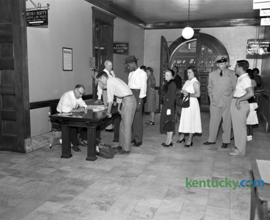 Because of the great number of Fayette countians registering to vote in the November election, the county clerk's office placed an extra desk in the hall outside the registration office on September 5, 1952 to take care of the overflow. At left, Robert Ledford, deputy clerk, registered Bill DeRossitt while others waited in line in the Fayette County Courthouse hallway. The voter registration office was to close on September 6 until after the election, which took place November 4. A total of 578 persons registered on the 5th. Of these, 339 were Democrats, 200 Republicans, and 39 Independents. That year's presidential election was between Republican, General Dwight D. Eisenhower, and Democrat Adlai Stevenson. Eisenhower was a landslide winner, carrying 39 states to Stevenson's 9, including Kentucky. Herald-Leader Archive Photo