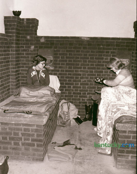 Two Transylvania University coeds, Anna Gaye McMahon, 19, left, and Teresa Gibson, 19, spent the night in the tomb of Constantine Rafinesque in the basement of Old Morrison on October 26, 1976. The eccentric professor taught at Transylvania during the early 19th century and was nationally known for his studies in botany. He was booted out of the school by Transy president Horace Holley in 1827. Tradition says Rafinesque placed a curse of the university that strikes every seven years. Transy students annually paid homage to Rafinesque with a convocation, torchlight parade and dance around Halloween. The two coeds decided the previous spring that it would be a wild, crazy thing to do. Gaye slept on Rafinesque's crypt and Gibson slept atop the coffin of Sauveur F. Bonfils, another Transy professor who has shared the tomb since 1939. Photo by John C. Wyatt | Staff