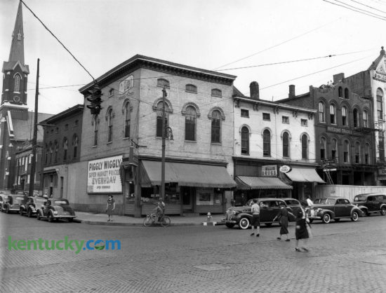 The Pggly-Wiggly grocery store in downtown Lexington at the corner of Broadway and Short Street, Oct. 1941. Six months later, two buildings shown here would be torn down and replaced by a new one-story Kroger supermarket. The Kroger featured 5,520 square feet of floor space and a new style of checkout counters. In each of the three checkout lanes, the carts were rolled inside the checking counter so they could be easily reached by the clerks and out of the way of customers. The two buildings on the right side of the picture is the Lexington Opera House. In the 1970's the Opera House was purchased by the Lexington Center Corporation and a side entrance was added to the complex. Herald-Leader archive photo