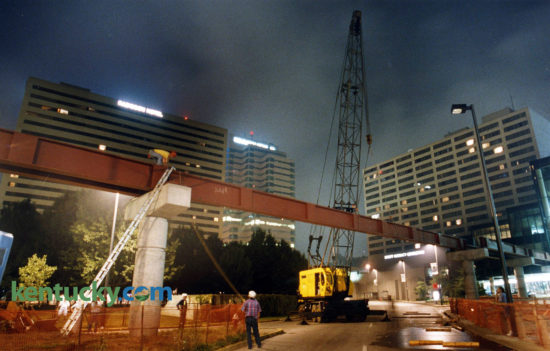 Workers erected one of the last beams supporting a walkway leading from the second floors of Victorian Square to the Lexington Center, July 17, 1993. Parts of Main and Vine streets were closed during the overnight hours as the 96-foot, 43,000-pound beam was put in position. The pedway opened later in the fall, giving pedestrians the ability to to walk through a complete circuit of enclosed passageways linking the Radisson Plaza Hotel, the Market Place, Victorian Square and the Lexington Center. Photo by Mark Cornelison | staff