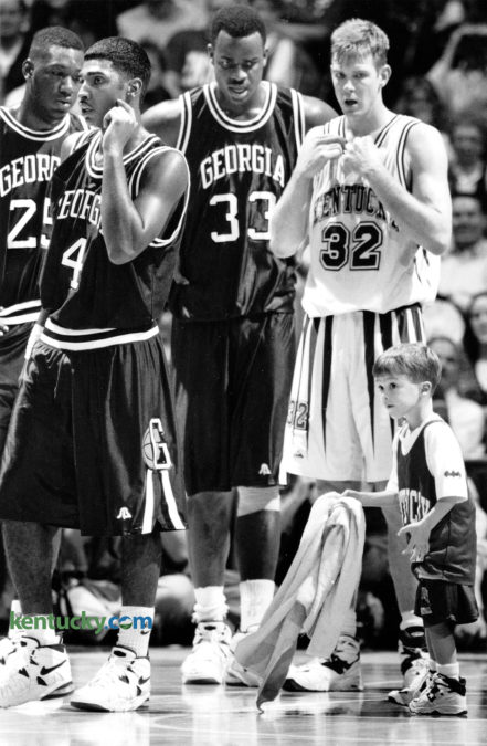 Ryan Pitino, Kentucky Coach Rick Pitino's 4-year-old son, was put to work during the UK-Georgia basketball game January 14, 1995, helping keep the Rupp Arena floor dry for the perspiring likes of Carlos Strong (25), Ty Wilson (4), Charles Claxton (33) and Jared Prickett (32). Photo by Frank Anderson | staff