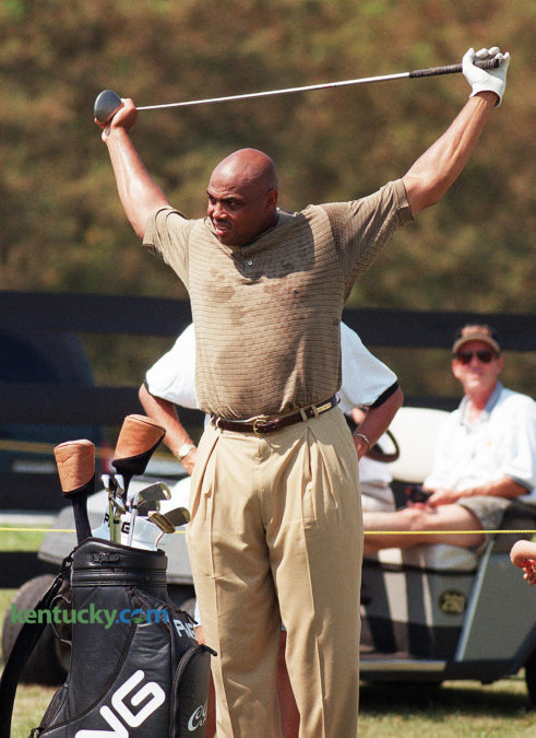 Professional basketball star Charles Barkley stretches during the Central Baptist Hospital Charity Classic Aug. 22, 1998 at Lexington's Kearney Hill Golf Links. The Houston Rockets star sprayed comments like shots on his way to a 30-over 102. Barkley cussed a time or two and flung his "Biggest Big Bertha" into the pond on No. 17 but always remained affable. On the first fairway, Jason Dunaway of Corinth asked Barkley to pose for a picture with 4-month-old Austin Rogers. "I'm not supposed to," Barkley said. Then, relenting, "Let's do it right quick." After teeing off on No. 2: "It was fat like Oprah." At No. 3, he stopped at a refreshment stand, bought a Diet Pepsi and tipped server Johna East. A fan asked if Barkley was wearing a lucky shirt. "This is a free shirt," he said. "I guess you could consider that lucky." After shooting a quadruple-bogey 9 on No. 7: "Ooh, I'm tired! That was a lot of work, y'all." When he hit his tee shot into the water and sent Big Bertha following on No. 17, 10-year-old Chad Fyffe of Frankfort waded in nearly chest high to retrieve the club. Barkley autographed the driver at the next tee. "I have two drivers in my bag for special occasions," Barkley said later. "But I did hit that great drive on 18. I'm just mad I didn't hit that ball into the water sooner with that other driver." Photo by David Perry | staff